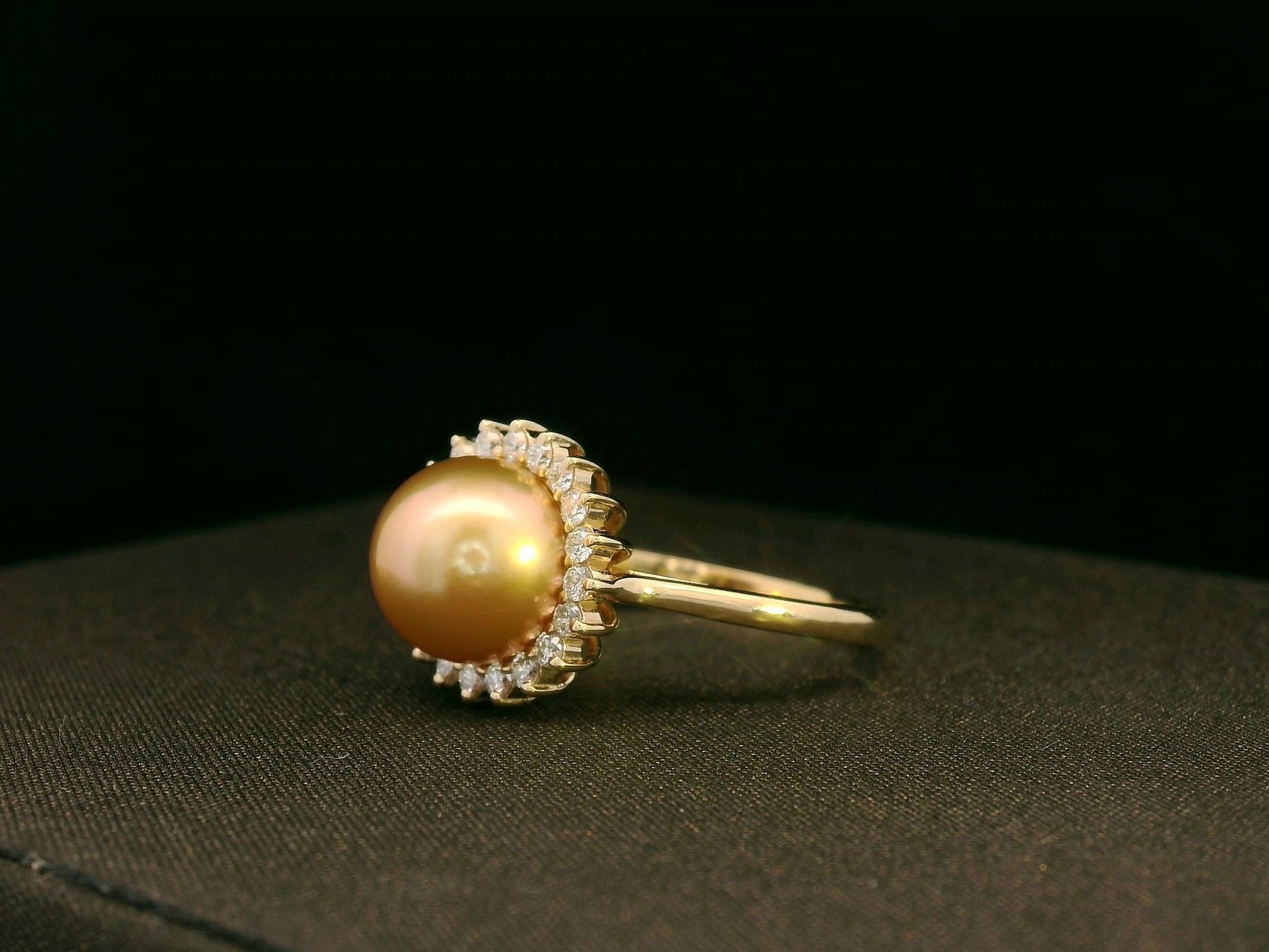 Side view highlighting pearl centerpiece and sparkling diamond halo