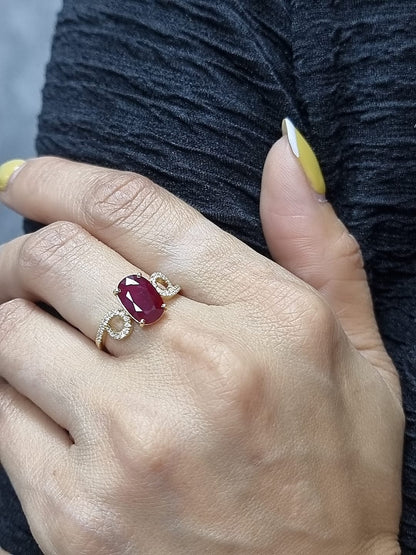 Ring on finger showcasing ruby and sparkling diamond details