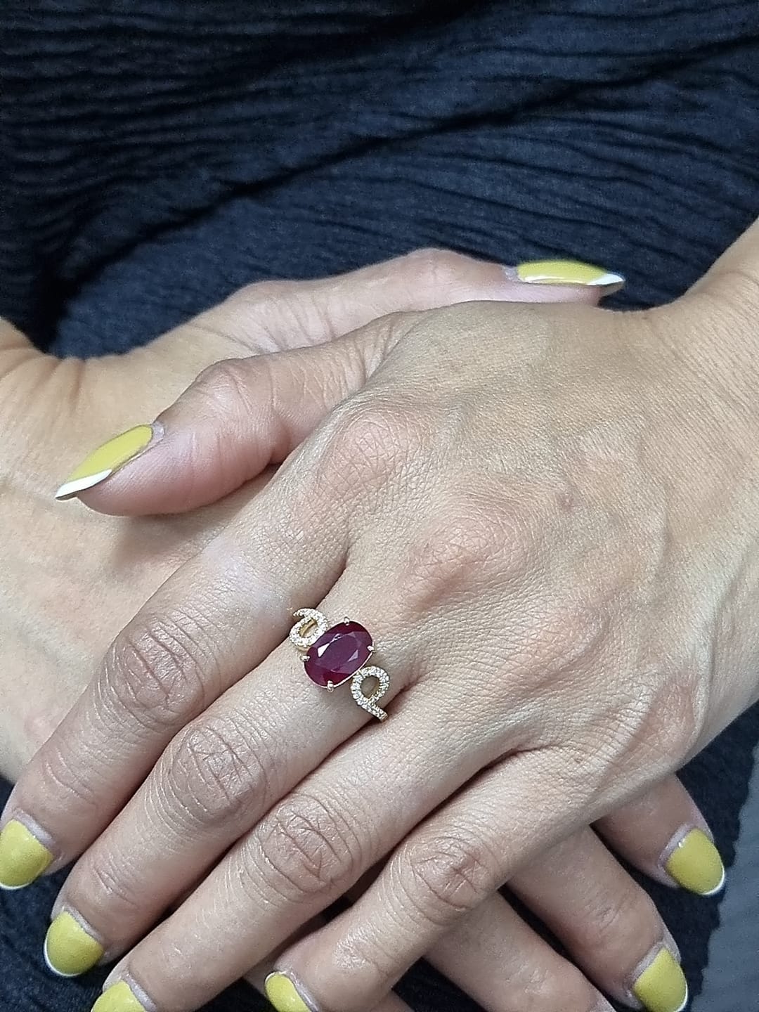 Ring on finger showcasing ruby and sparkling diamond details
