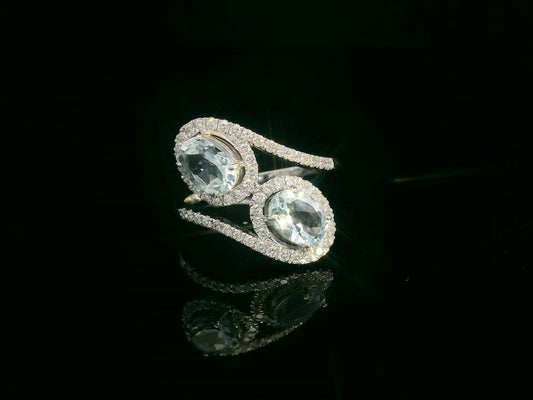 Front view of 18k white gold ring with two oval aquamarines and 0.39 ct diamond halos
