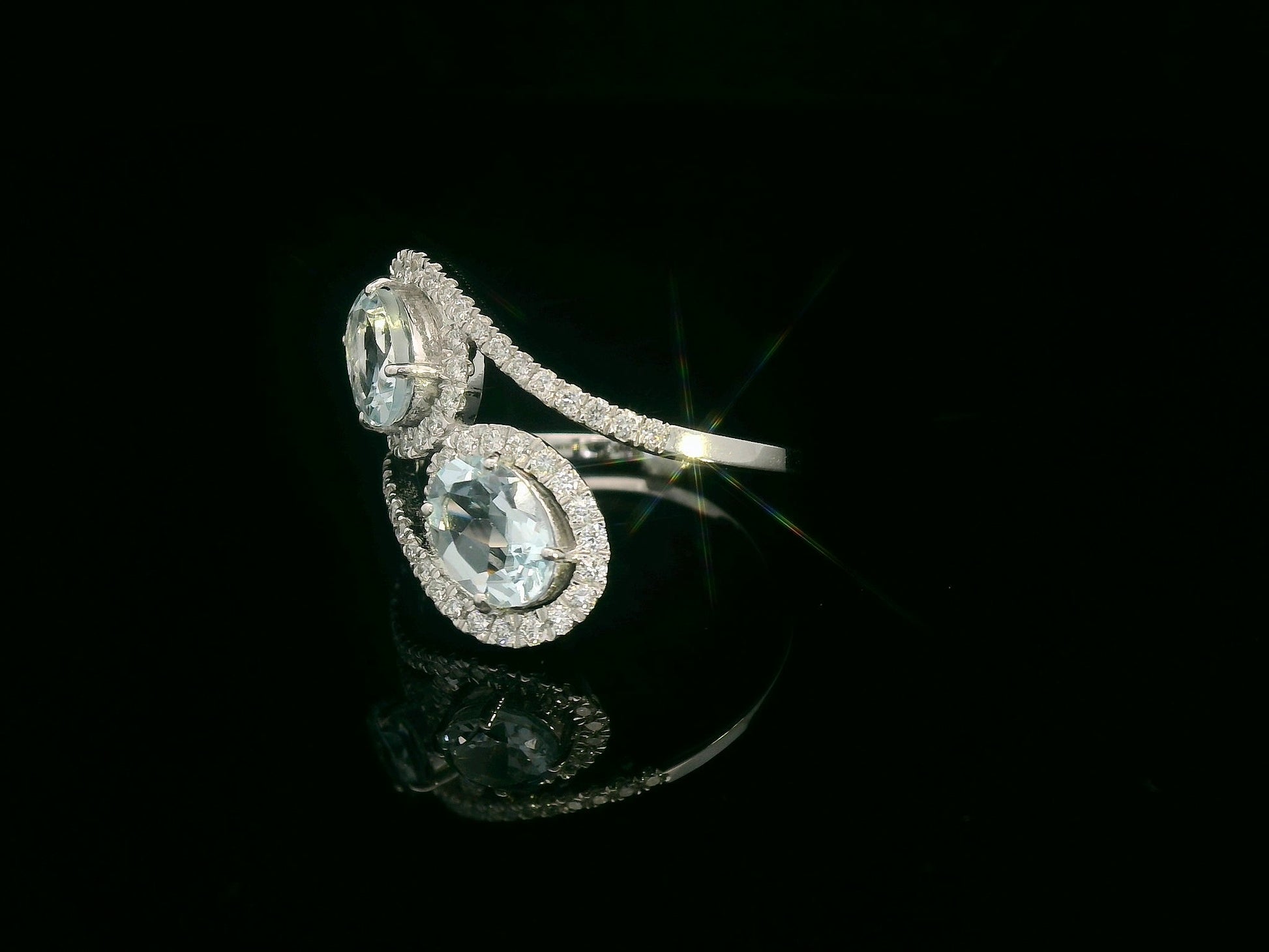 Side view showing bypass shank with pave-set diamonds cradling twin aquamarines