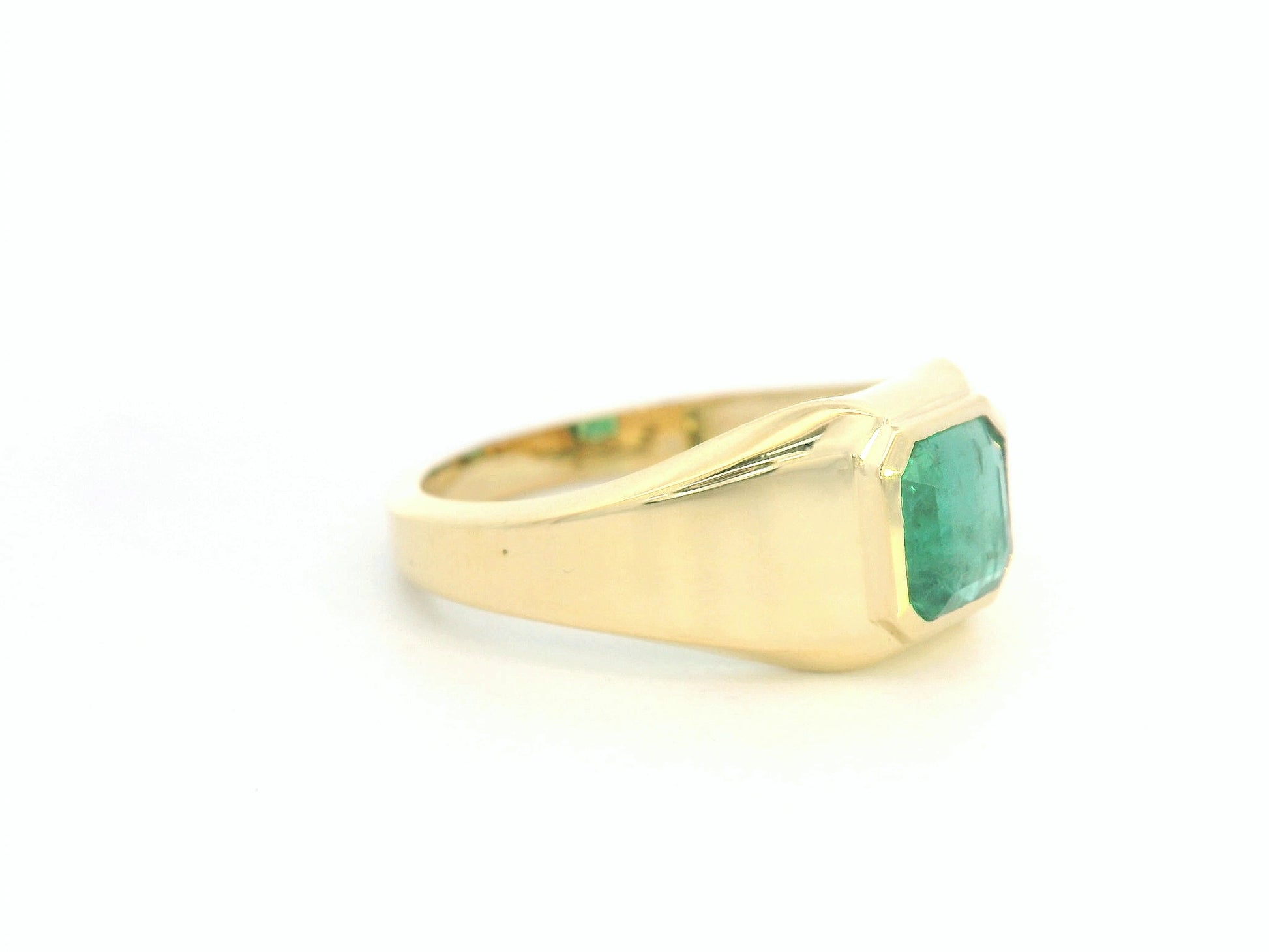 Side view showing substantial gold band and sleek emerald centerpiece
