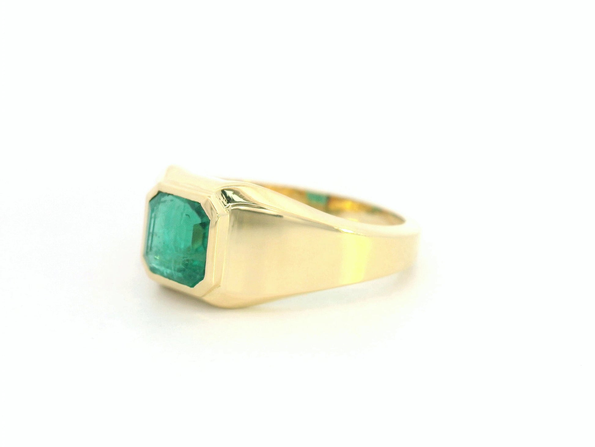 Side view showing substantial gold band and sleek emerald centerpiece