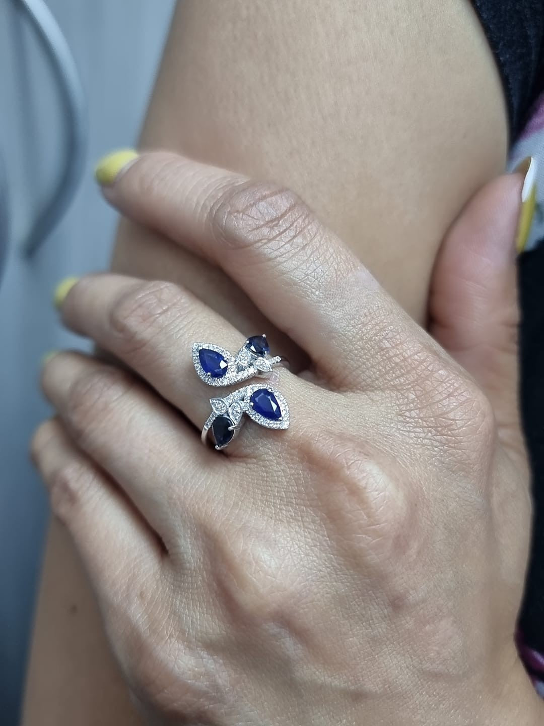 Ring on finger showcasing elegant white gold band with sapphires and diamonds