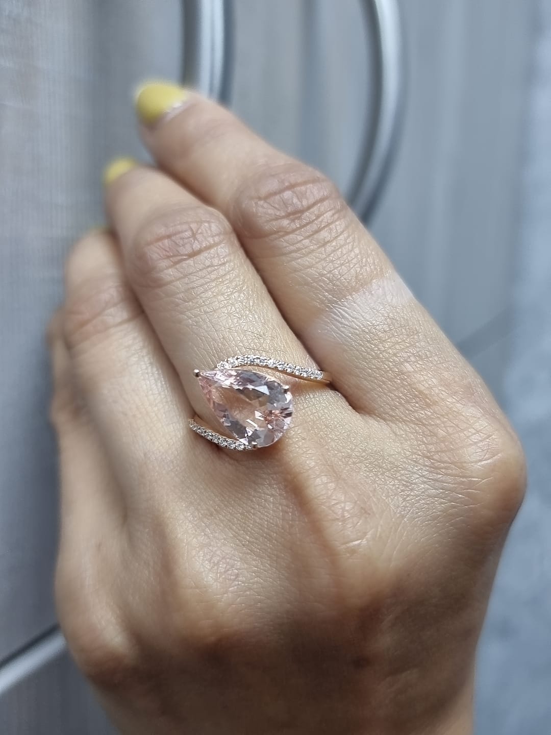 Ring on finger showcasing soft pink morganite and dazzling diamonds