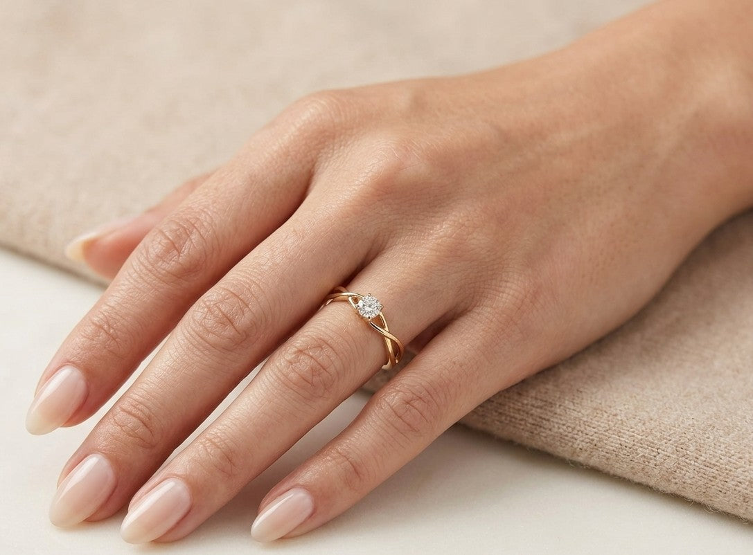 Round brilliant diamond solitaire ring in 18K yellow gold with elegant twisted open shoulders
