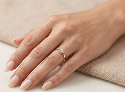 Round brilliant diamond solitaire ring in 18K yellow gold with elegant twisted open shoulders