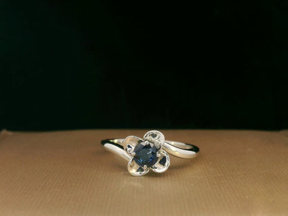 18k white gold ring with 0.55ct round sapphire in flower petal motif – certificate included