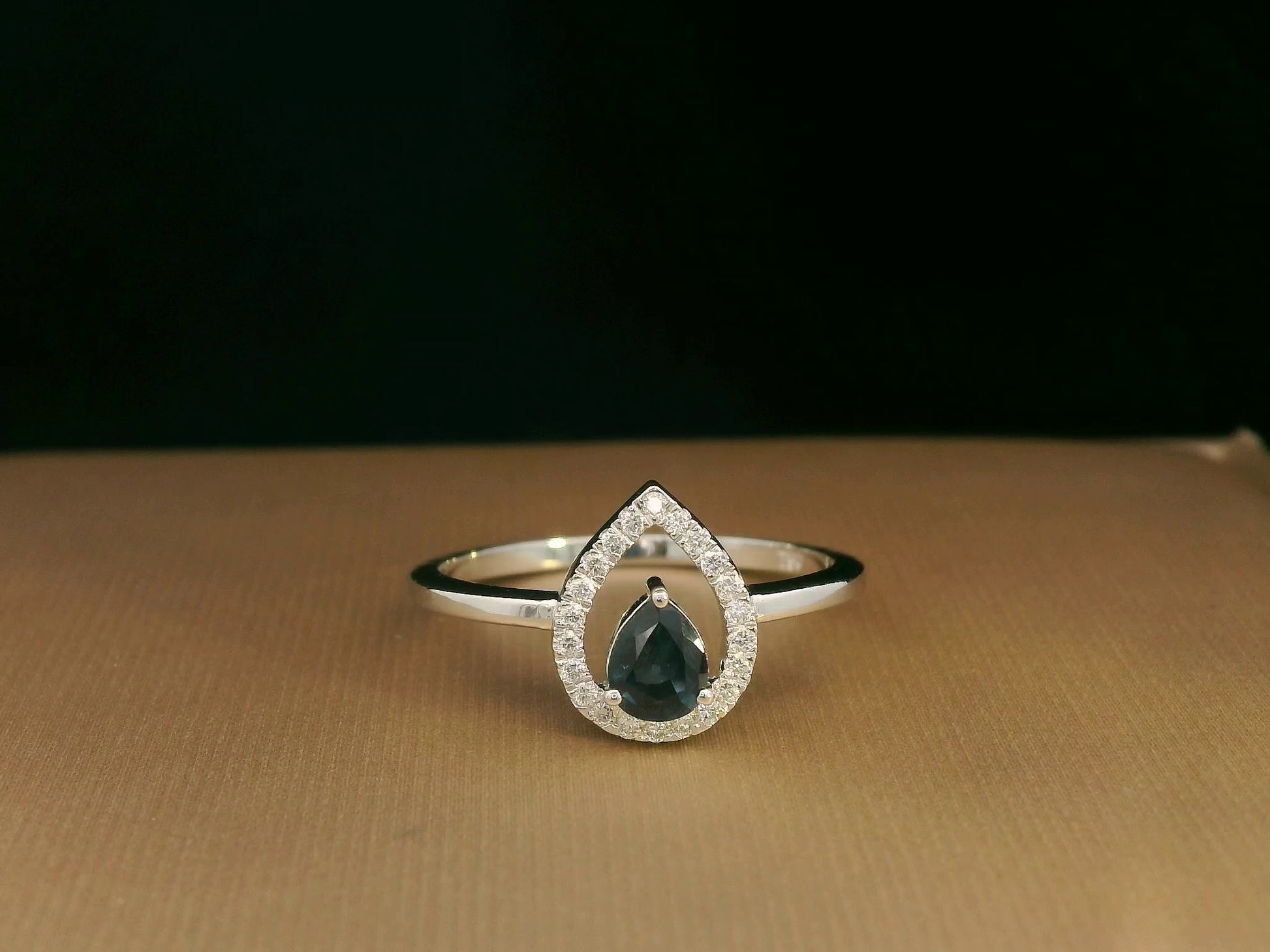 18k white gold ring with 0.41ct pear-cut blue sapphire and 0.11ct open diamond halo – certificate included