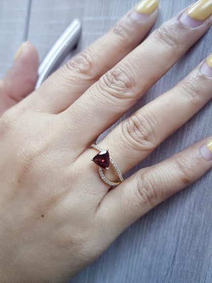 18k yellow gold ring with trillion-cut garnet and diamond crossover band. Comes with a certificate of authenticity