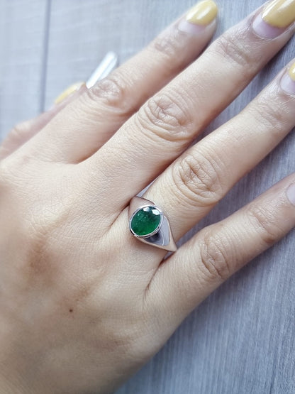 18K white gold men’s signet ring featuring a 1.80ct oval-cut emerald in a sleek bezel setting with a solid tapered band.