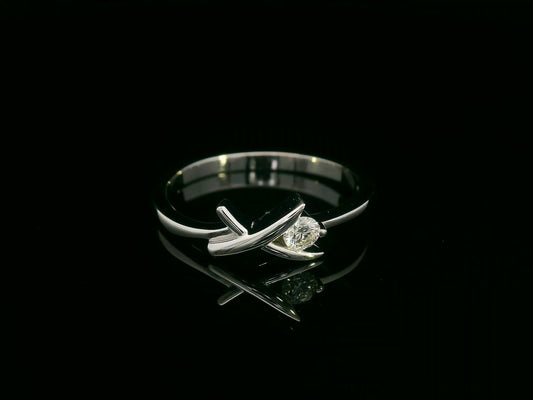 18K white gold ring featuring a 0.12 ct round diamond in a modern tension “X” design, with certificate of authenticity.