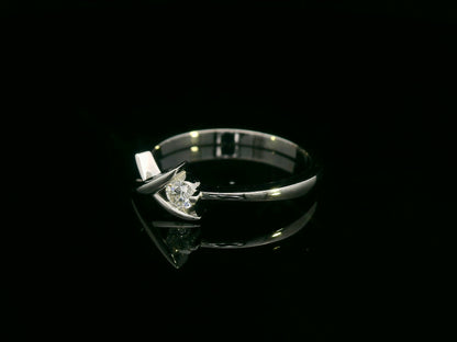 18K white gold ring featuring a 0.12 ct round diamond in a modern tension “X” design, with certificate of authenticity.