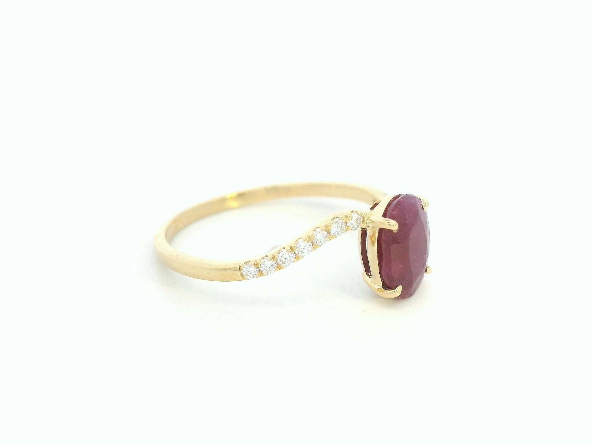 18K yellow gold ruby and diamond wave ring featuring an oval 1.56ct ruby and 0.13ct round diamonds in a flowing wave design.