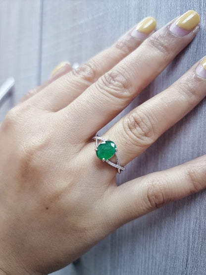 18K white gold ring featuring a 1.59ct oval-cut emerald with 0.10ct diamonds set into a twisted split-shank design.