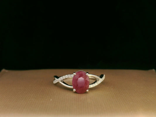 18K white gold ring featuring a 1.47ct oval-cut ruby with 0.11ct diamonds set along a twisted split-shank band.