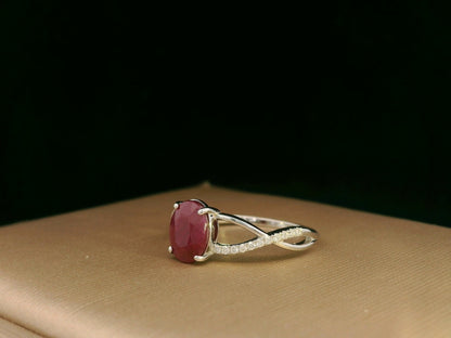 18K white gold ring featuring a 1.47ct oval-cut ruby with 0.11ct diamonds set along a twisted split-shank band.