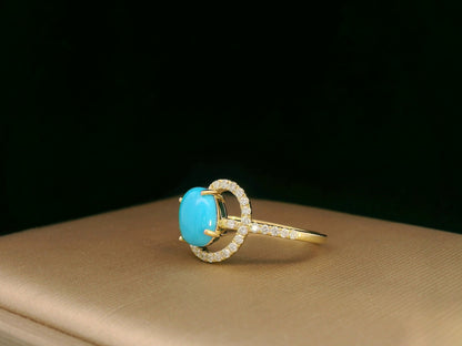 18K yellow gold ring featuring a 1.21ct oval turquoise center with 0.24ct diamonds in an asymmetrical halo and diamond-lined shank.