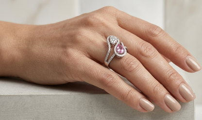 18K white gold Toi et Moi ring featuring a 0.74 carat pear-shaped pink sapphire, pear diamond cluster and 0.59 carats of natural diamonds in a flowing pavé halo design.