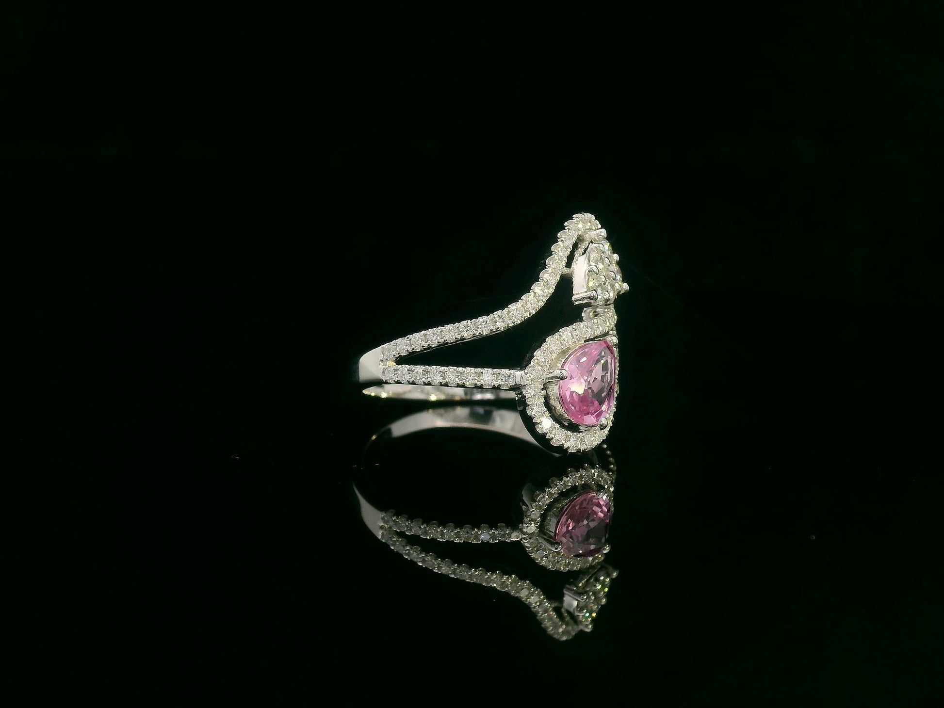 18k white gold ring with 0.74ct pear-shaped pink sapphire and 0.59ct diamonds in a sculptural double-drop design.