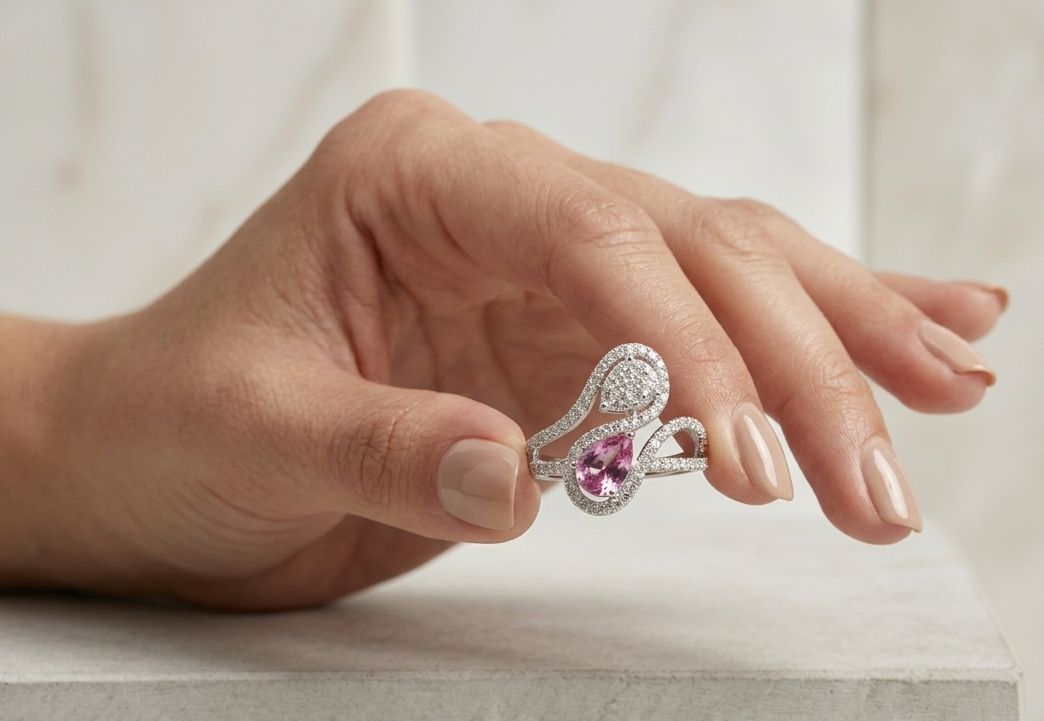 18K white gold Toi et Moi ring featuring a 0.74 carat pear-shaped pink sapphire, pear diamond cluster and 0.59 carats of natural diamonds in a flowing pavé halo design.