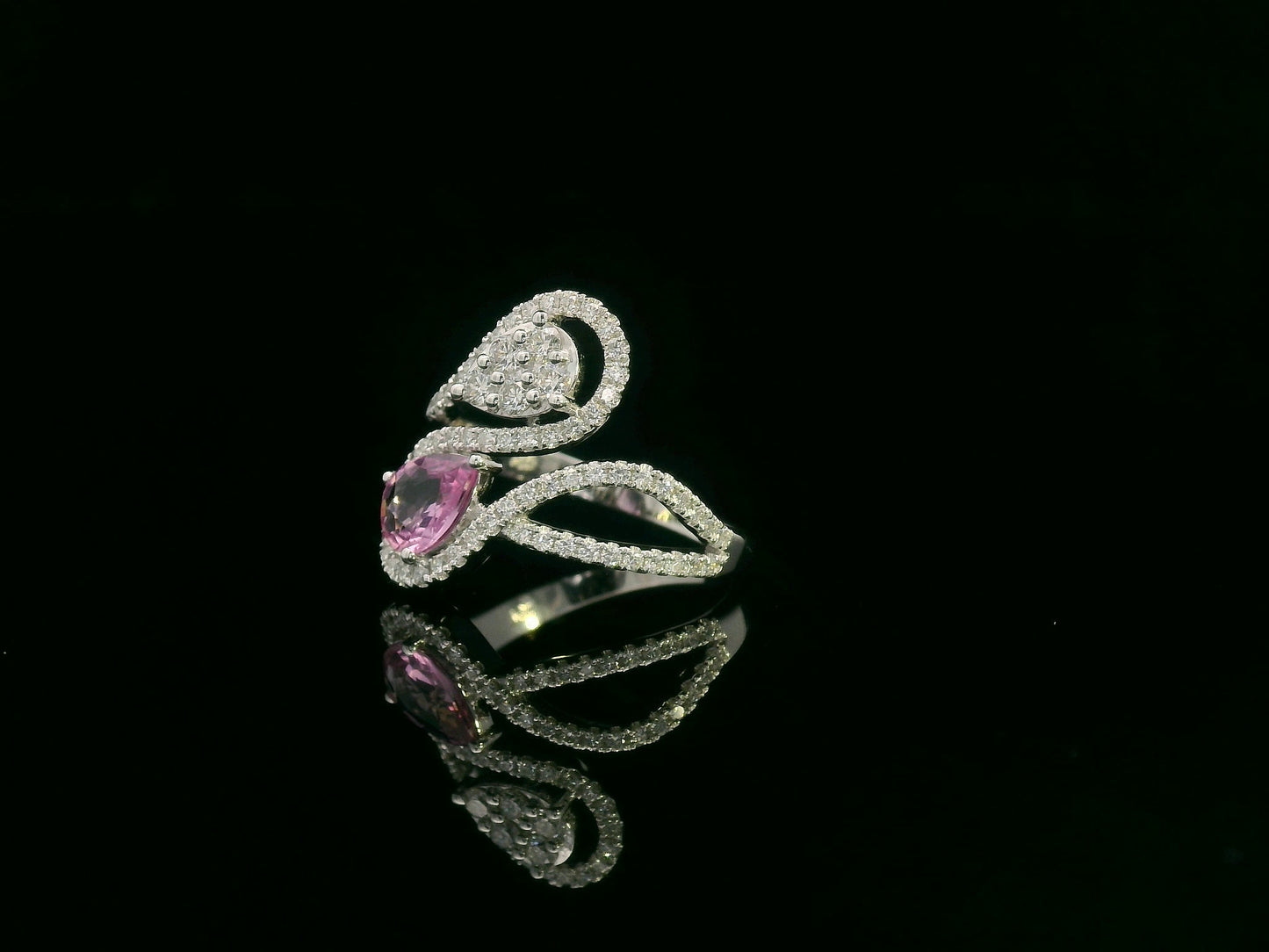 18k white gold ring with 0.74ct pear-shaped pink sapphire and 0.59ct diamonds in a sculptural double-drop design.