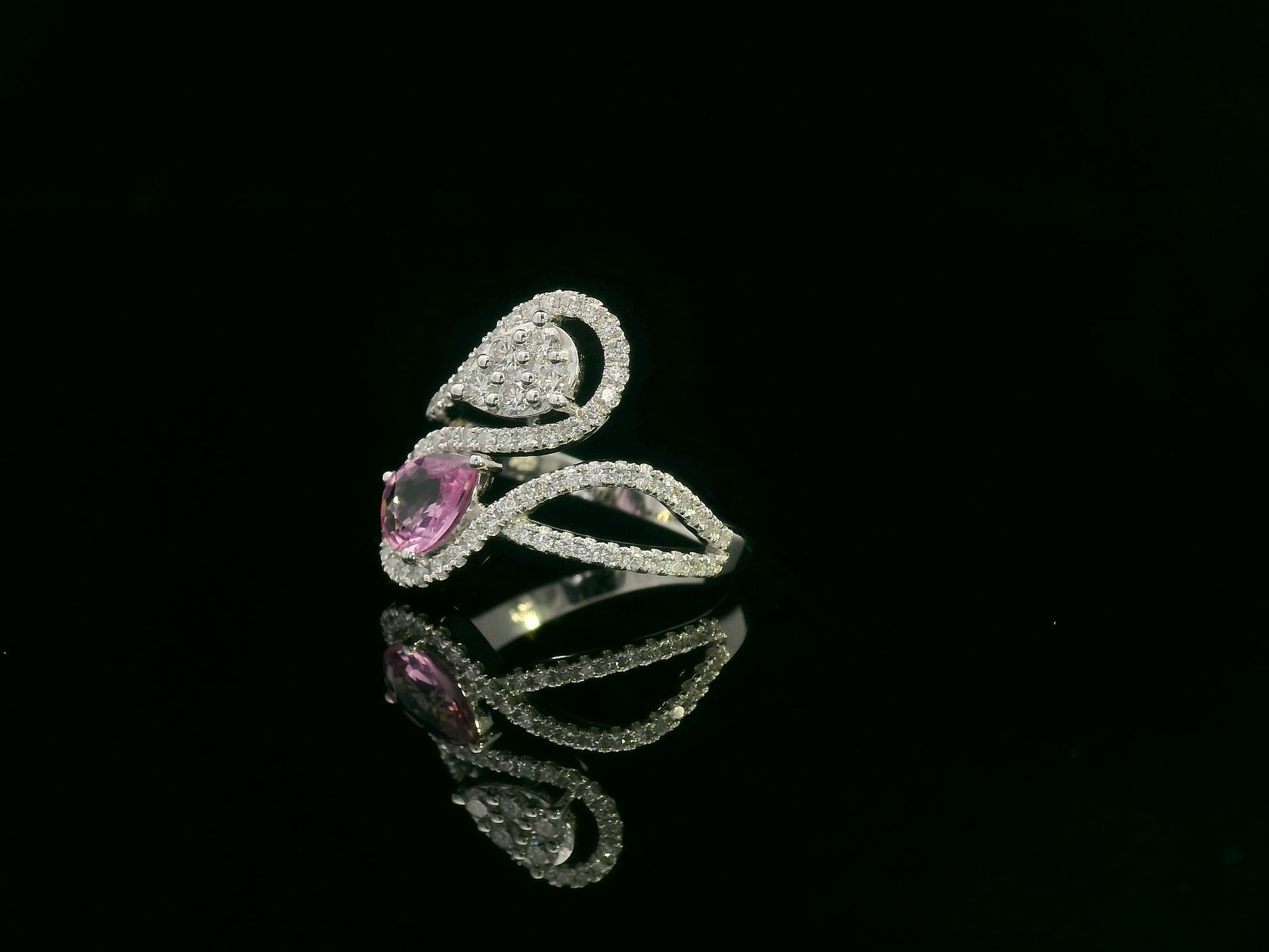 18k white gold ring with 0.74ct pear-shaped pink sapphire and 0.59ct diamonds in a sculptural double-drop design.