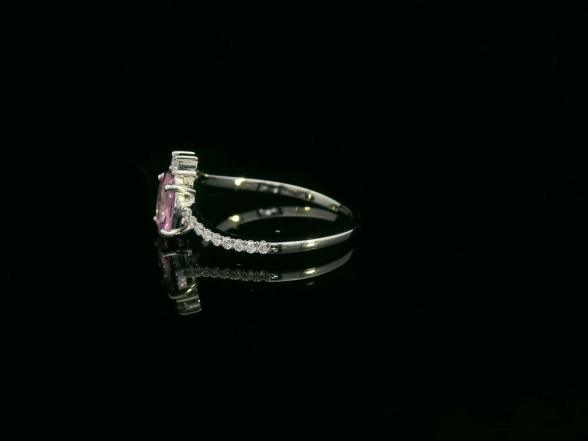 18K white gold ring featuring a 0.75ct oval Pink Sapphire with 0.12ct diamonds on an asymmetric split band.