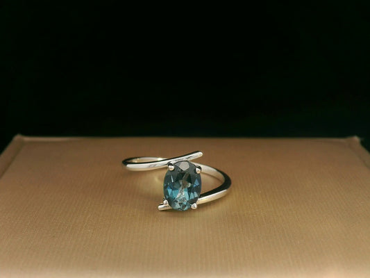 18K white gold bypass ring featuring a 1.49ct oval London Blue Topaz prong-set between gracefully crossing bands.