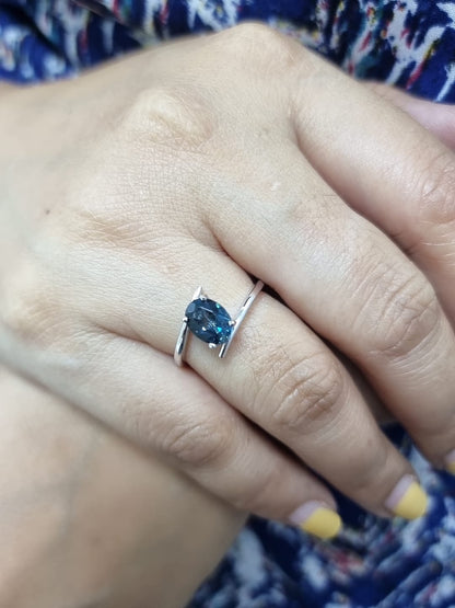 18K white gold bypass ring featuring a 1.49ct oval London Blue Topaz prong-set between gracefully crossing bands.