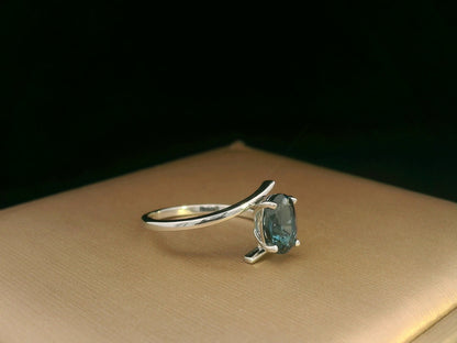 18K white gold bypass ring featuring a 1.49ct oval London Blue Topaz prong-set between gracefully crossing bands.