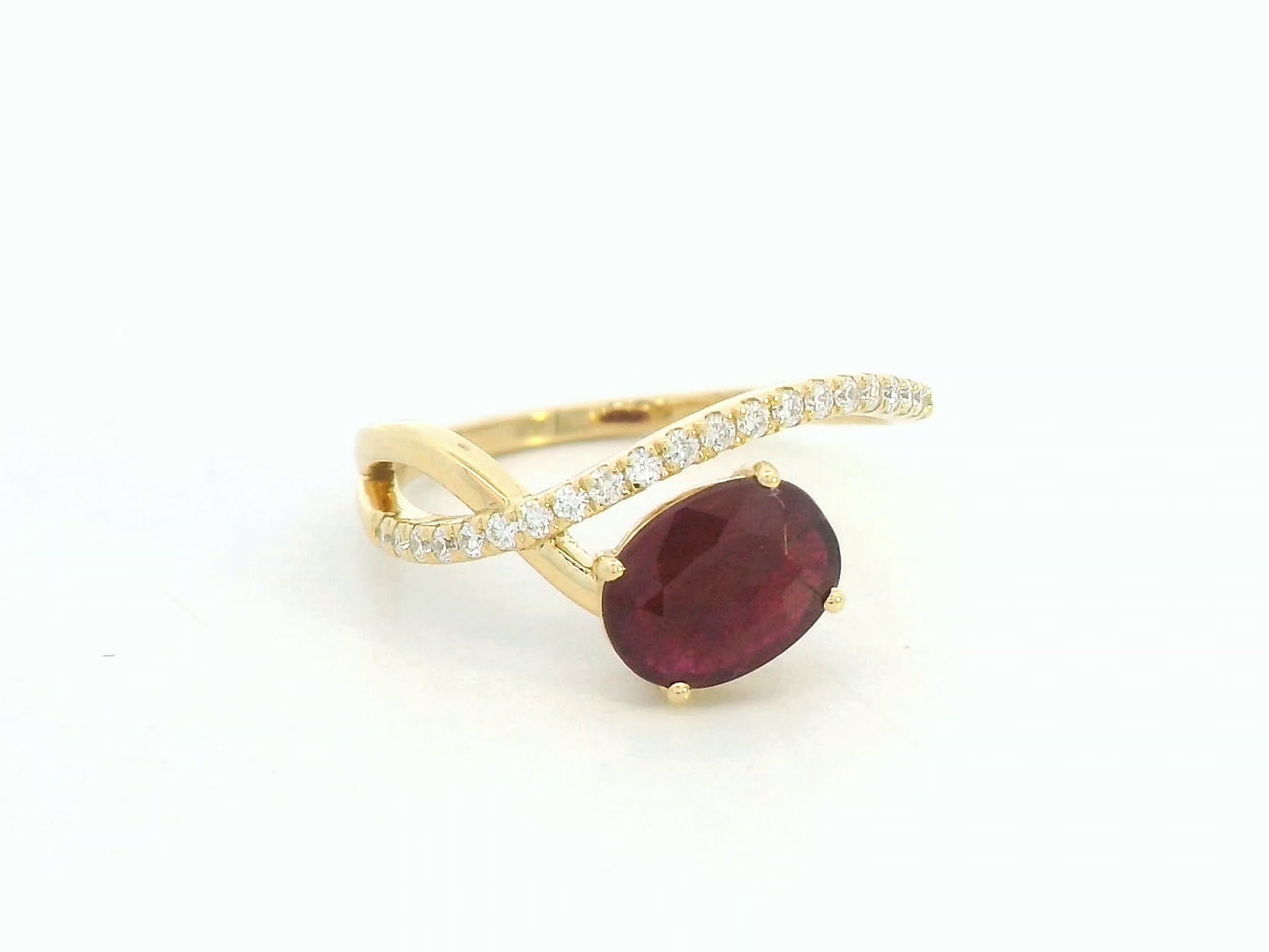 18K yellow gold oval ruby bypass ring with round diamond accents, modern luxury design