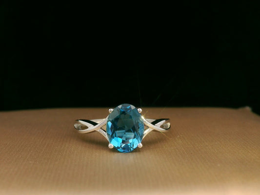 18K white gold bypass ring with 1.86 carat oval London Blue Topaz, elegant statement design