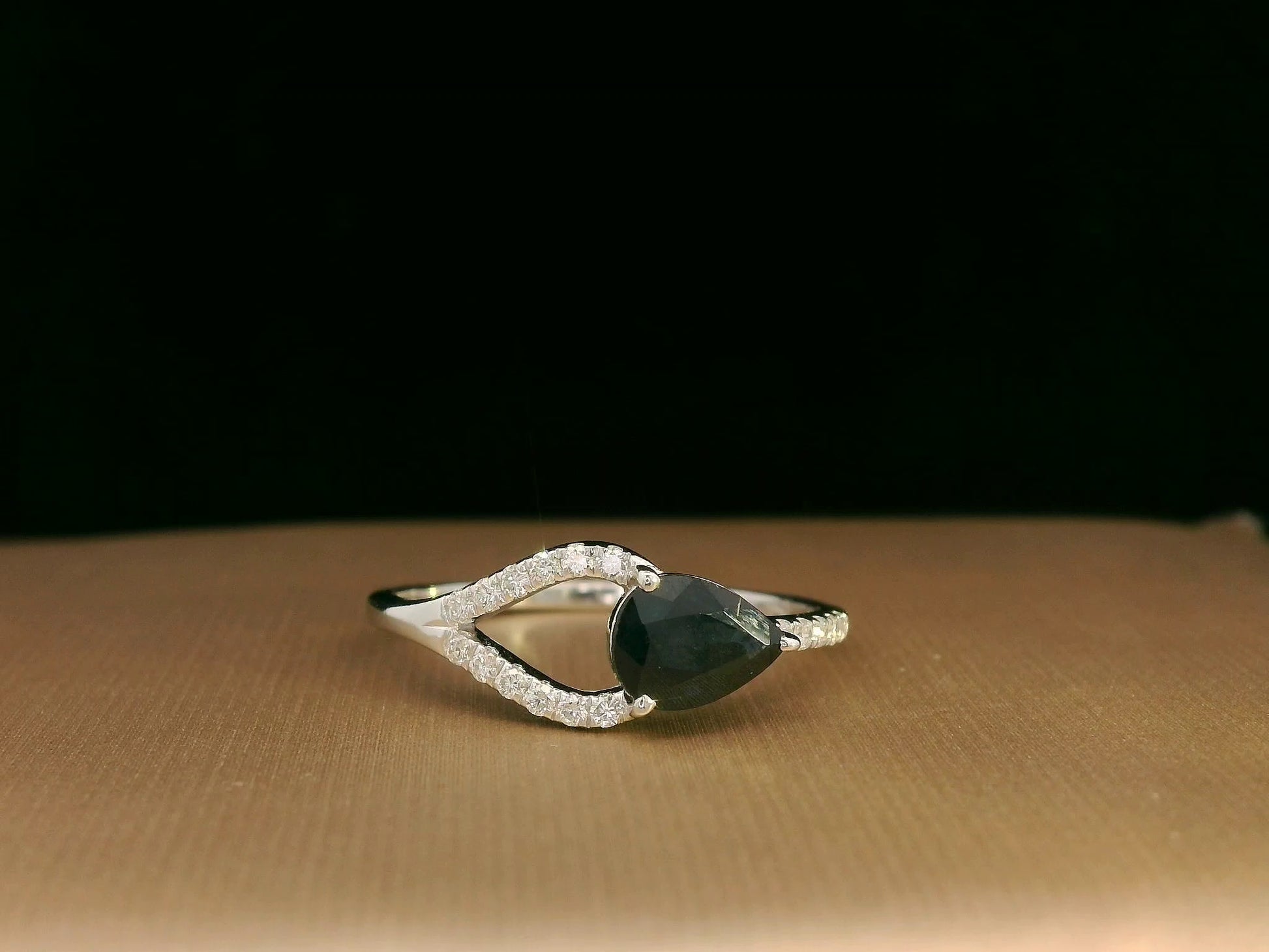 18K white gold asymmetrical ring with 0.78 carat pear-shaped blue sapphire and pavé diamonds, elegant contemporary design
