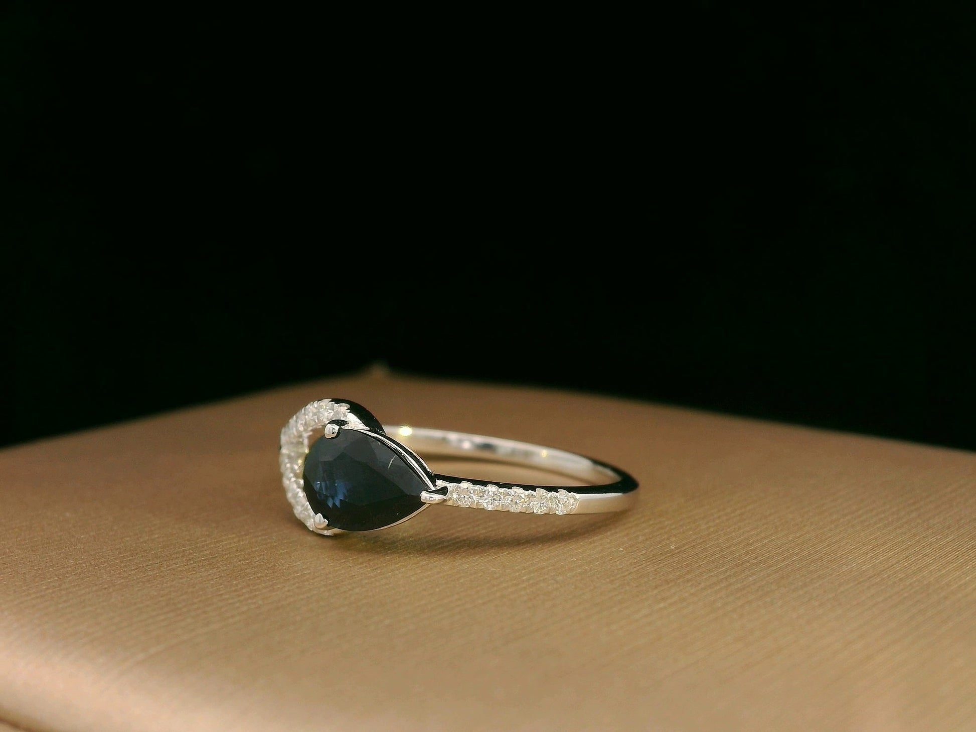 18K white gold asymmetrical ring with 0.78 carat pear-shaped blue sapphire and pavé diamonds, elegant contemporary design