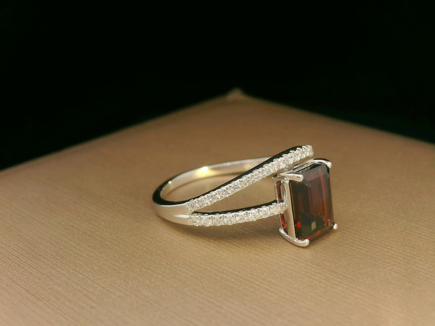 18K white gold bypass ring with emerald-cut garnet and diamond accents