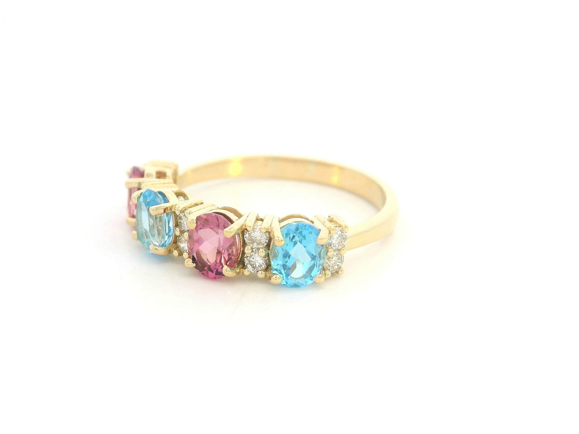 18K yellow gold band with alternating oval pink and blue sapphires and round diamond accents