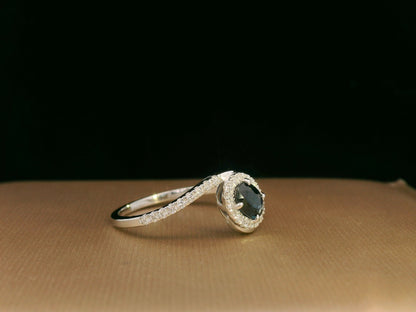 Oval blue sapphire halo ring with pavé diamonds in 18K white gold, bypass design