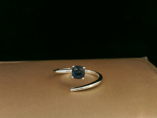 18K gold bypass ring with 0.49 carat cushion-cut blue sapphire, sleek modern design