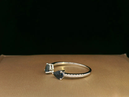 18K white gold open cuff ring with two teardrop-cut blue sapphires (0.70 carat) and 0.10 carat diamond pavé, modern minimalist design