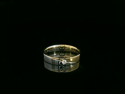 Unisex 18K two-tone wedding band with 0.03 carat bezel-set diamond, sleek modern flat profile
