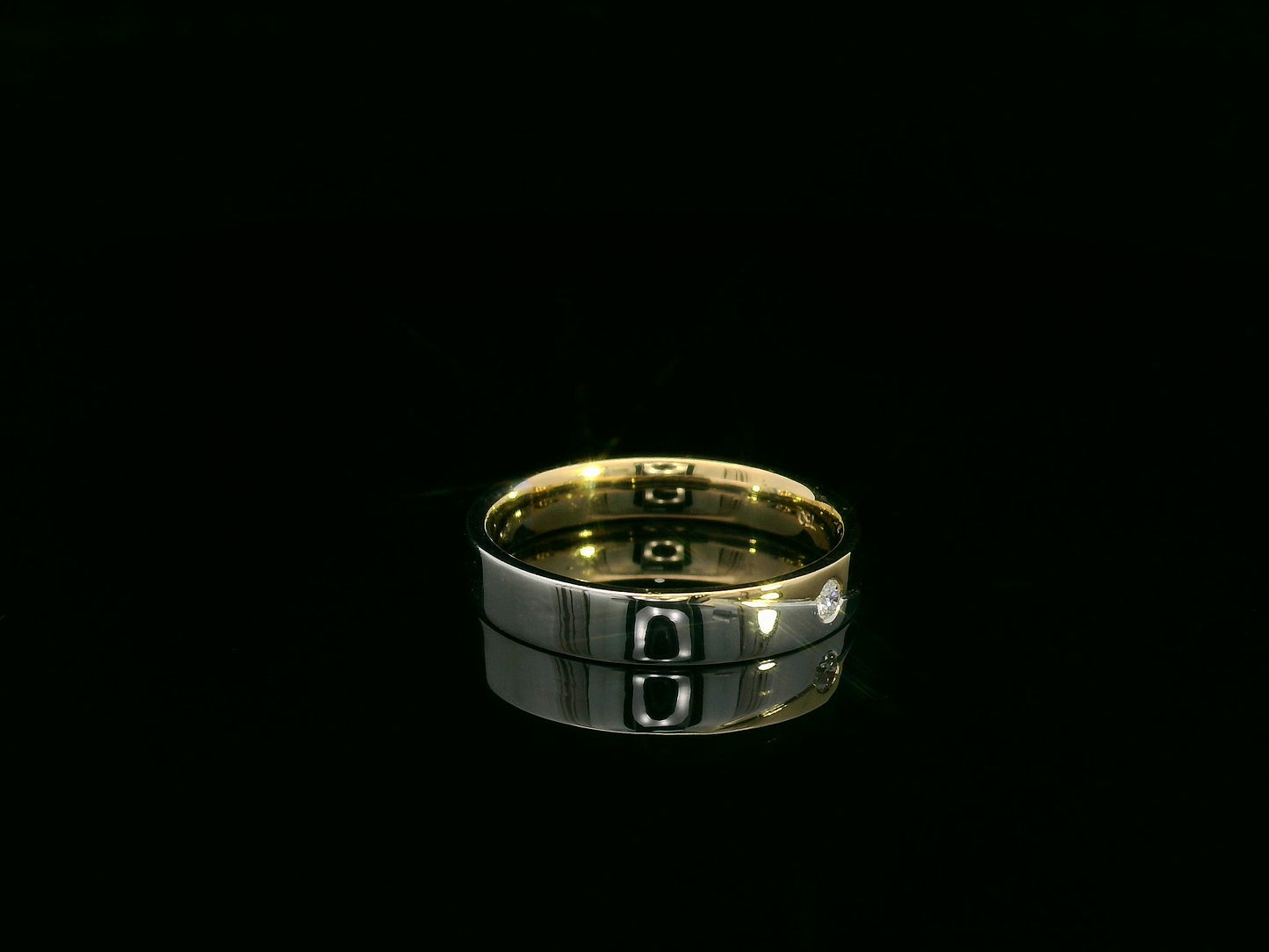 Unisex 18K two-tone wedding band with 0.03 carat bezel-set diamond, sleek modern flat profile