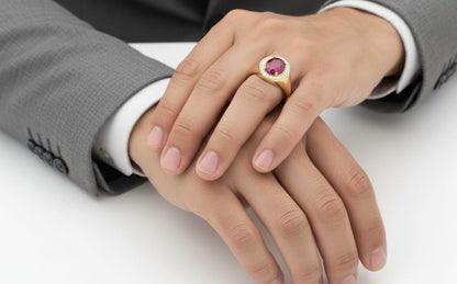 Men’s 18K yellow gold ring featuring 2.58 ct oval ruby with diamond halo and tapered band