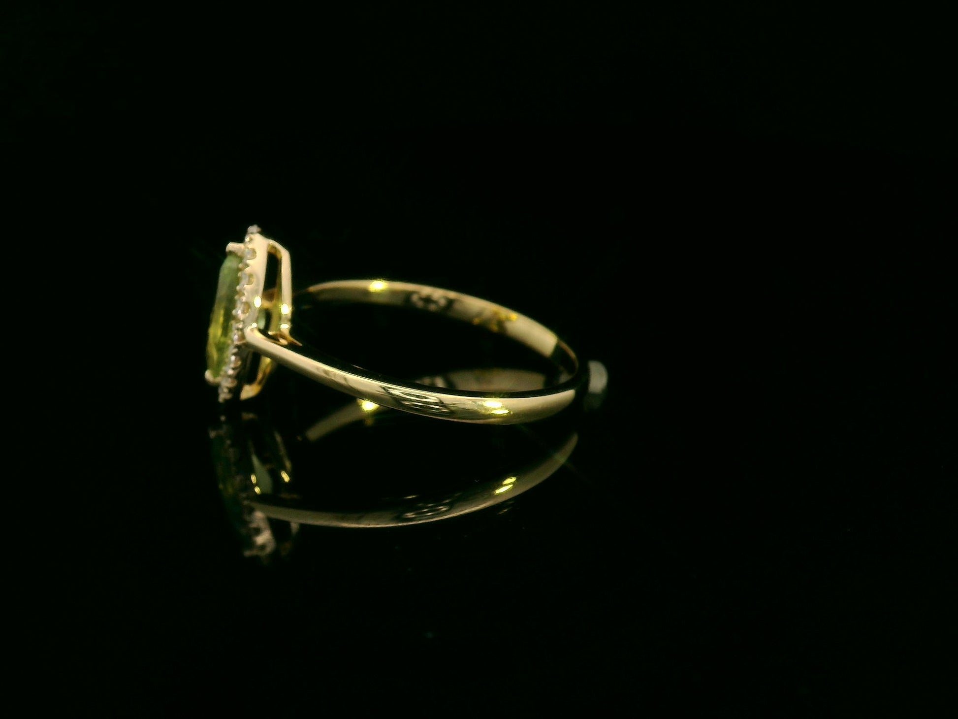 18k yellow gold ring featuring a 0.64ct marquise Peridot surrounded by a 0.15ct diamond halo