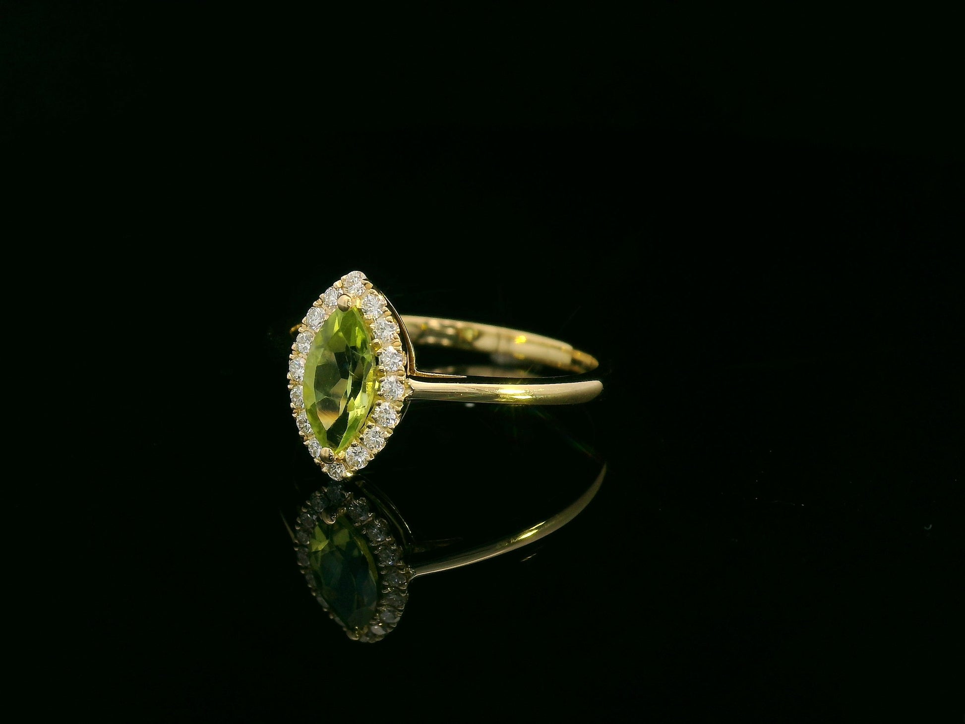 18k yellow gold ring featuring a 0.64ct marquise Peridot surrounded by a 0.15ct diamond halo