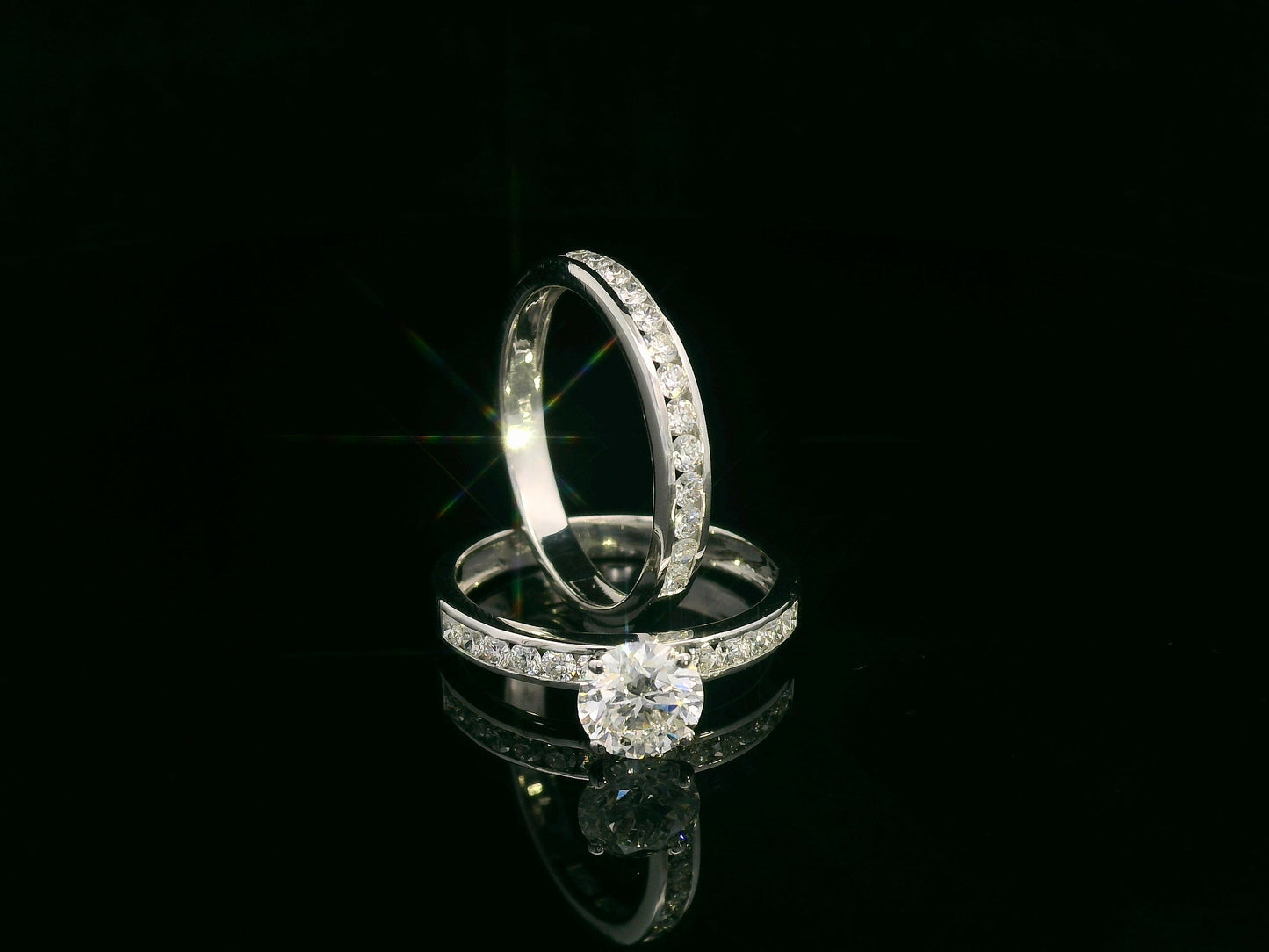 18K white gold bridal set featuring 1.01 carat D color GIA diamond with channel-set diamond bands