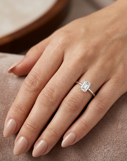 18K white gold solitaire ring featuring a 0.90 carat IGI certified natural emerald cut diamond with VS2 clarity and D colour in a classic four-prong setting.