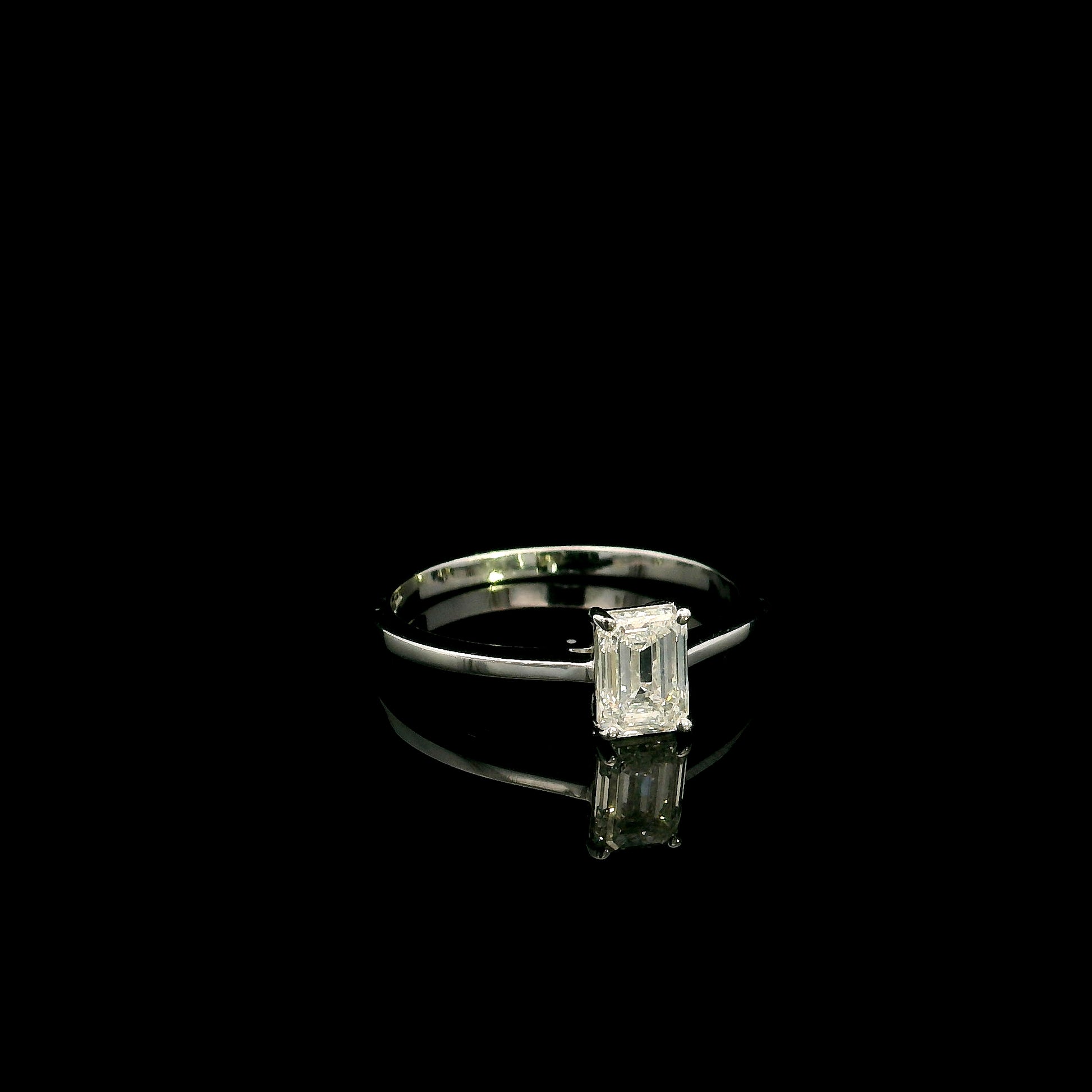 18K white gold solitaire ring featuring a 0.90 carat IGI certified natural emerald cut diamond with VS2 clarity and D colour in a classic four-prong setting.