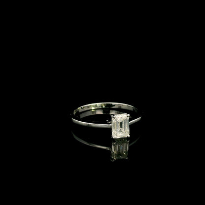 18K white gold solitaire ring featuring a 0.90 carat IGI certified natural emerald cut diamond with VS2 clarity and D colour in a classic four-prong setting.