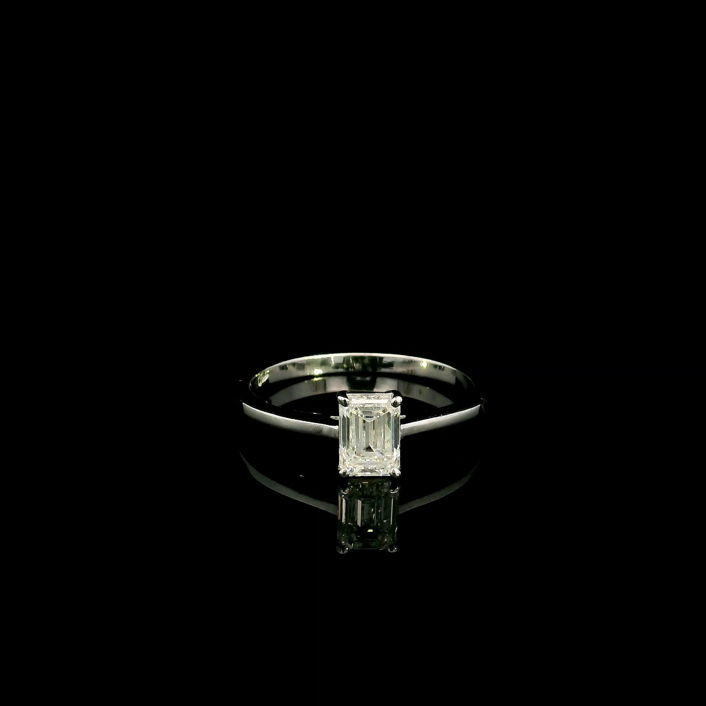 18K white gold solitaire ring featuring a 0.90 carat IGI certified natural emerald cut diamond with VS2 clarity and D colour in a classic four-prong setting.